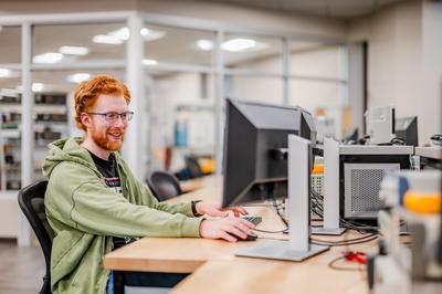 girl sitting at desk typing on computer