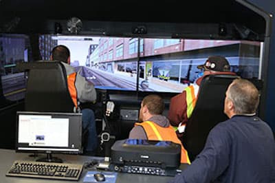 several people sitting in front of virtual driving machine