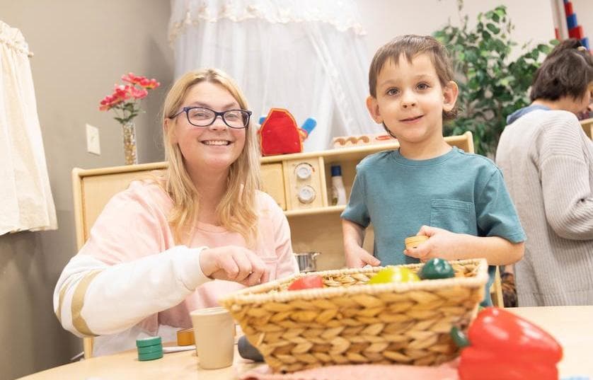 childcare teacher with toddler playing with blocks