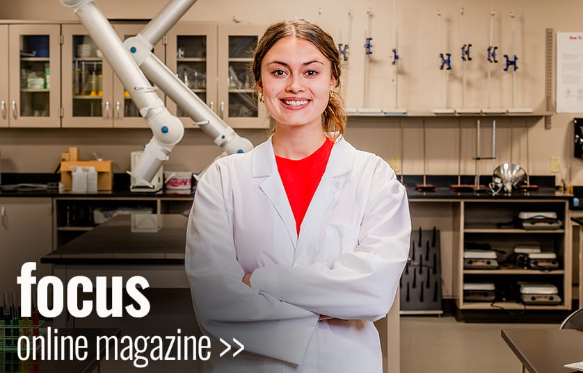 Focus magazine cover of a female in a white lab coat standing with arms folded and smiling