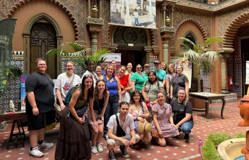Group of students standing for picture with rain forest in background
