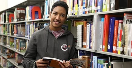 Student with book in library