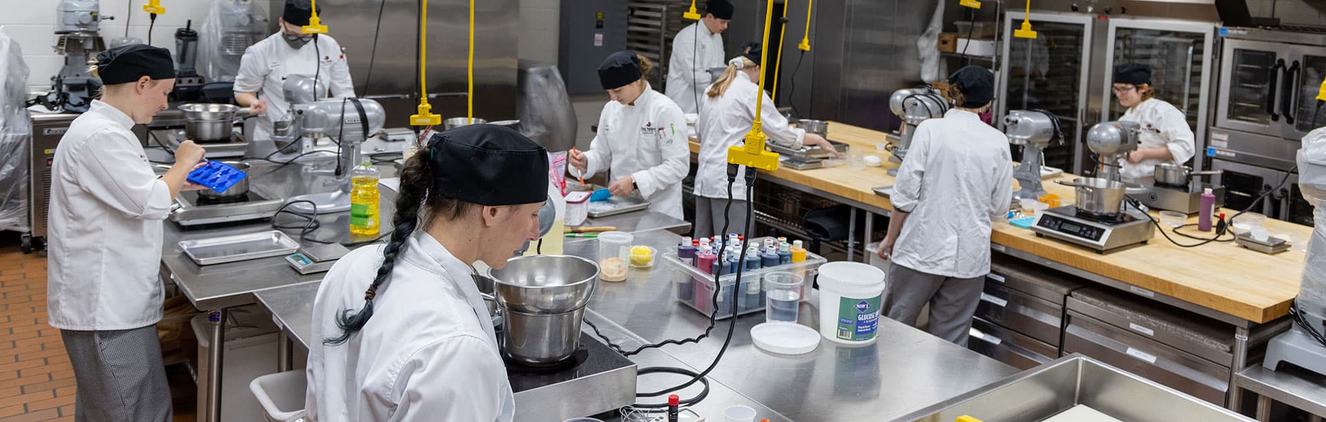 students learning culinary arts in kitchen classroom