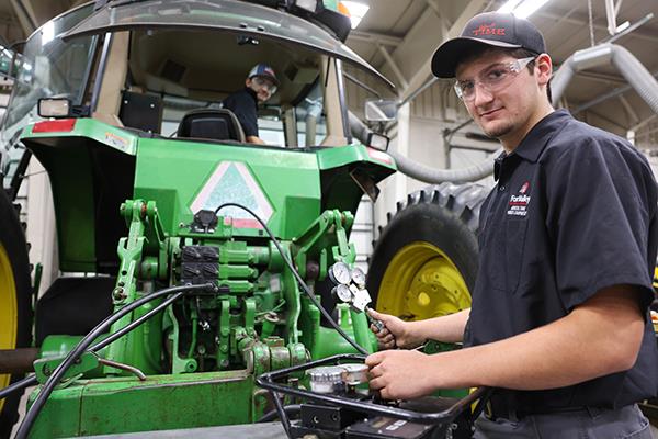 Two men working on John Deere equipment